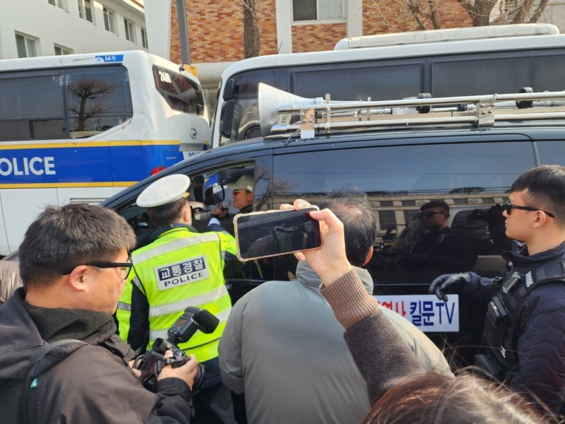 21일 오전 메가폰을 단 검은 봉고차가 헌재 주변을 끊임 없이 돌며 시위하다가 경찰의 제지를 받고 있다. / 뉴스1 권진영 기자