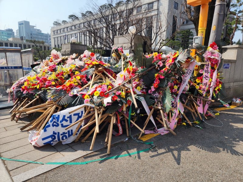 헌재 정문 인근에 쓰러진 채 방치되고 있는 화환들 / 뉴스1 권진영 기자
