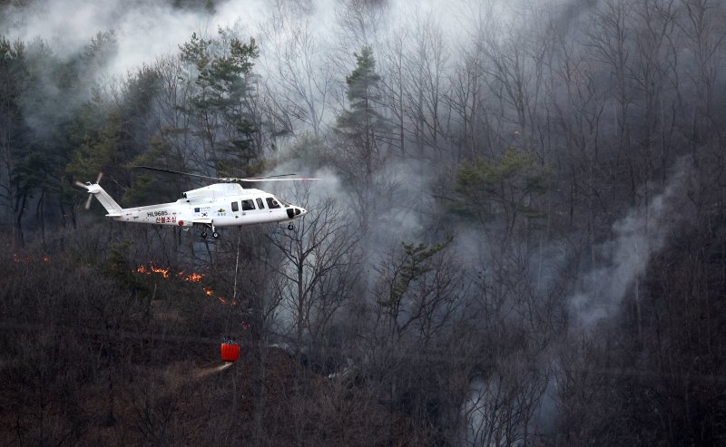 [의성=뉴시스] 이무열 기자 = 22일 경북 의성군 의성읍 원당리 마을 인근까지 산불이 번져 산불진화헬기가 산불 진화에 나서고 있다. 2025.03.22. lmy@newsis.com