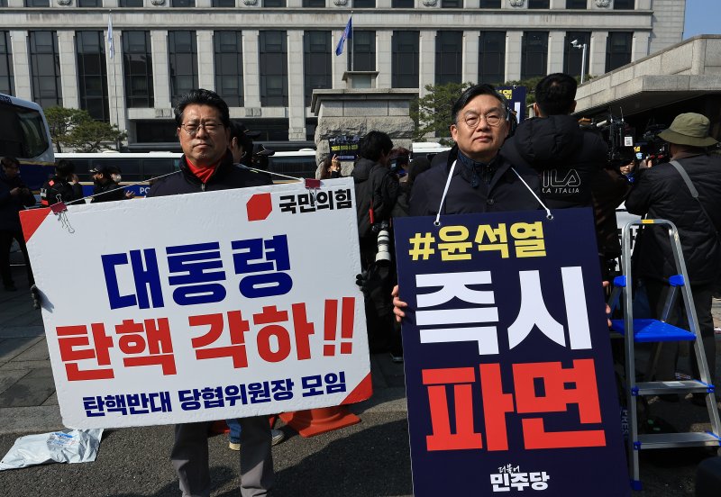 김윤 더불어민주당 비례대표 국회의원(오른쪽)과 홍윤오 국민의힘 수원시을 당협위원장이 21일 오전 서울 종로구 재동 헌법재판소 앞에서 각하와 파면을 촉구하며 1인 시위를 하고 있다. 2025.3.21/뉴스1 ⓒ News1 박정호 기자