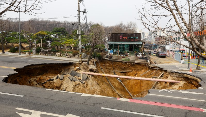 [서울=뉴시스] 황준선 기자 = 25일 서울 강동구 명일초등학교 인근 도로에서 전날 발생한 싱크홀(땅 꺼짐) 사고 현장 모습. 2025.03.25. hwang@newsis.com