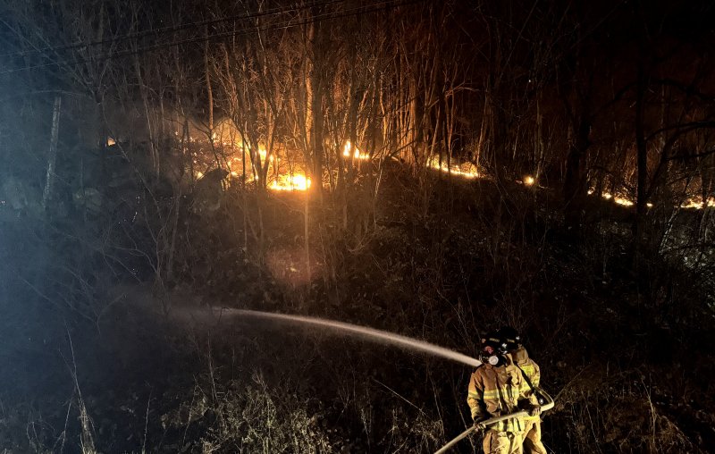 [무주=뉴시스] 김얼 기자 = 27일 전북 무주군 부남면의 한 주택에서 발생한 화재가 인근 산으로 번지자 소방관들이 화재를 진압하고 있다. 2025.03.27. pmkeul@newsis.com