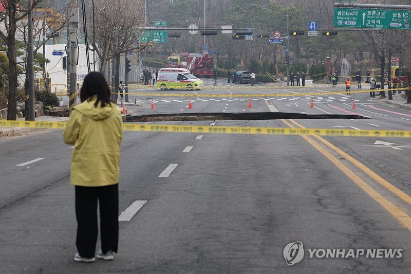 한 시민이 지난 3월 24일 서울 강동구 명일동에 발생한 싱크홀을 바라보고 있다. 연합뉴스