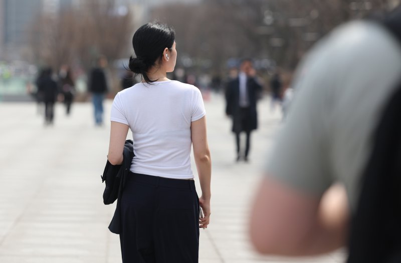 [서울=뉴시스] 김진아 기자 = 낮 기온이 20도 이상 오르는등 봄 날씨가 이어지고 있는 26일 서울 종로구 광화문광장에서 반팔은 입은 시민이 걸어가고 있다. 2025.03.26. bluesoda@newsis.com