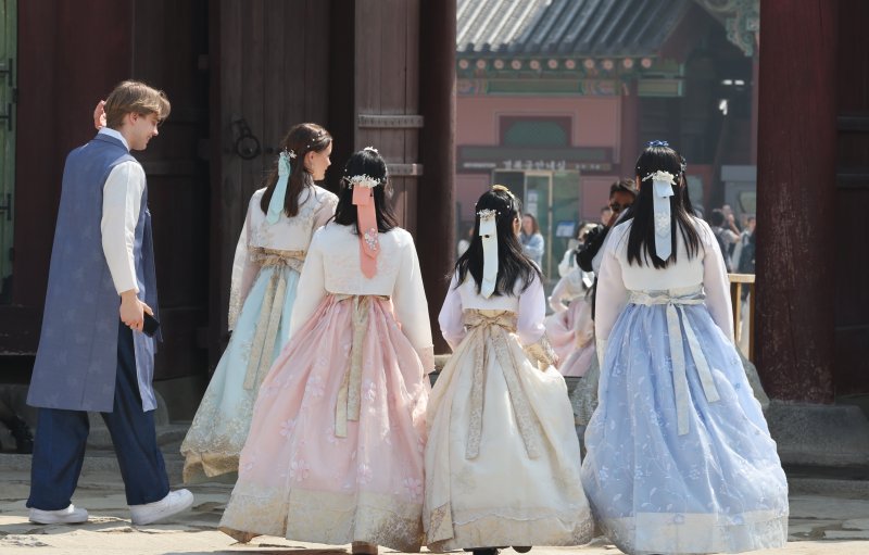 [서울=뉴시스] 김명원 기자 = 서울 지역 낮 최고기온이 23도까지 오른 23일 하늘거리는 봄색깔의 한복을 입은 관광객들이 서울 종로구 경복궁을 찾아 완연한 봄을 느끼며 관광하고 있다. 2025.03.23. kmx1105@newsis.com