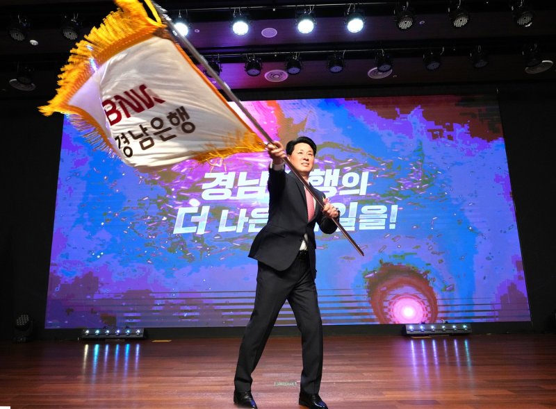 [울산=뉴시스] 1일 BNK경남은행 본사에서 열린 취임식에서 신임 김태한 은행장이 행기를 힘차게 흔들고 있다. (사진=경남은행 제공) 2025.04.01. photo@newsis.com *재판매 및 DB 금지