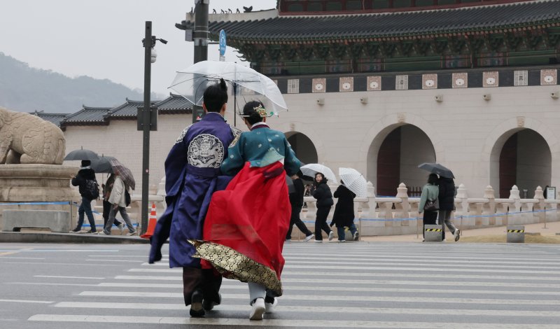 서울 경복궁 앞에서 한복을 입고 우산을 쓴 관광객이 발걸음을 재촉하고 있다.2025.3.2/뉴스1 ⓒ News1 박세연 기자