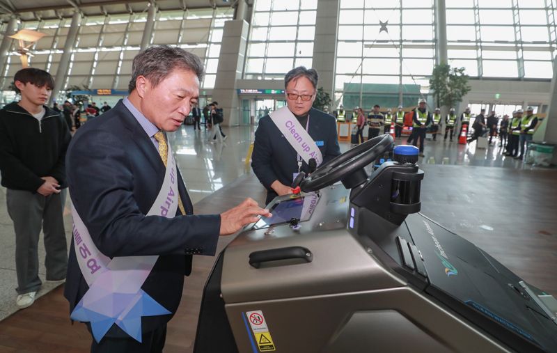 이학재 인천공항공사 사장(앞줄)이 지난 1일 인천공항 제1여객터미널에서 열린 '클린업 에어포트 캠페인'에서 자율주행 청소로봇 작동 시연을 하고 있다. 인천공항공사 제공