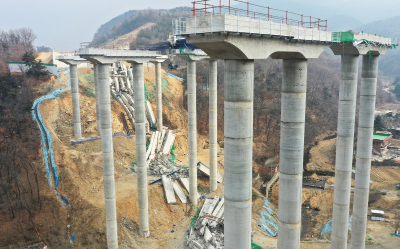 [안성=뉴시스] 김종택 기자 = 10명의 사상자가 발생한 경기도 안성시 서운면 산평리 '안성 고속도로 교각 붕괴' 현장에 26일 교각 상판이 처참하게 내려앉아 있다. 이번 붕괴 사고와 관련해 국토부는 해당 고속도로와 유사한 공법(DR 거더 런칭 공법)으로 건설되는 도로 공사를 전면 중지키로 했다. 2025.02.26. jtk@newsis.com