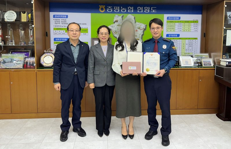 충북 괴산경찰서 관계자가 2일 전화금융사기(보이스피싱) 피해 예방에 이바지한 증평농협 직원에게 경찰서장 감사장을 수여하고 있다.(괴산경찰서 제공)/뉴스1