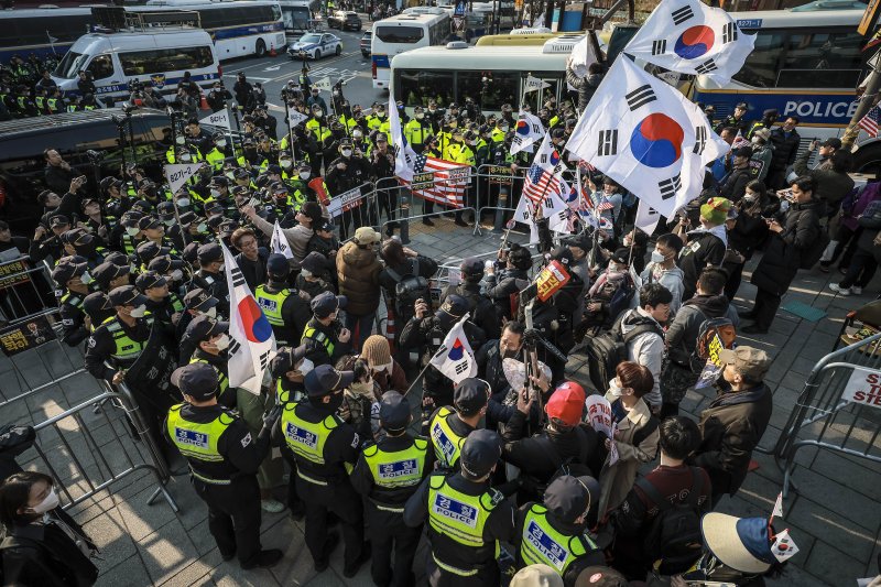 [서울=뉴시스] 정병혁 기자 = 윤석열 대통령 탄핵심판 선고일이 결정된 1일 서울 종로구 헌법재판소 인근에서 경찰이 시위 중이던 윤 대통령 탄핵 반대 참가자들을 헌법재판소 100m 밖으로 밀어내고 있다.2025.04.01. jhope@newsis.com