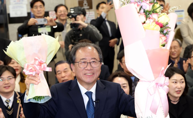 [부산=뉴시스] 하경민 기자 = 부산교육감 재선거 투표일인 2일 부산 부산진구 김석준 후보 선거사무소에서 김 후보가 당선이 유력해지자 꽃다발을 들고 지지자들에게 인사하고 있다. 2025.04.02. yulnetphoto@newsis.com