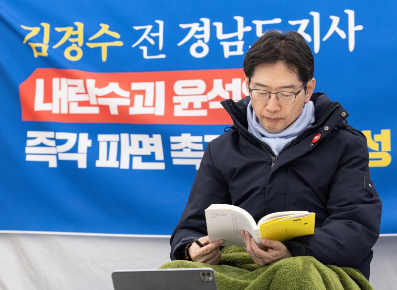 윤석열 대통령의 파면을 촉구하며 단식 농성에 나선 김경수 전 경남도지사가 17일 오후 서울 종로구 경복궁역 인근 농성장에서 책을 읽고 있다. 뉴스1