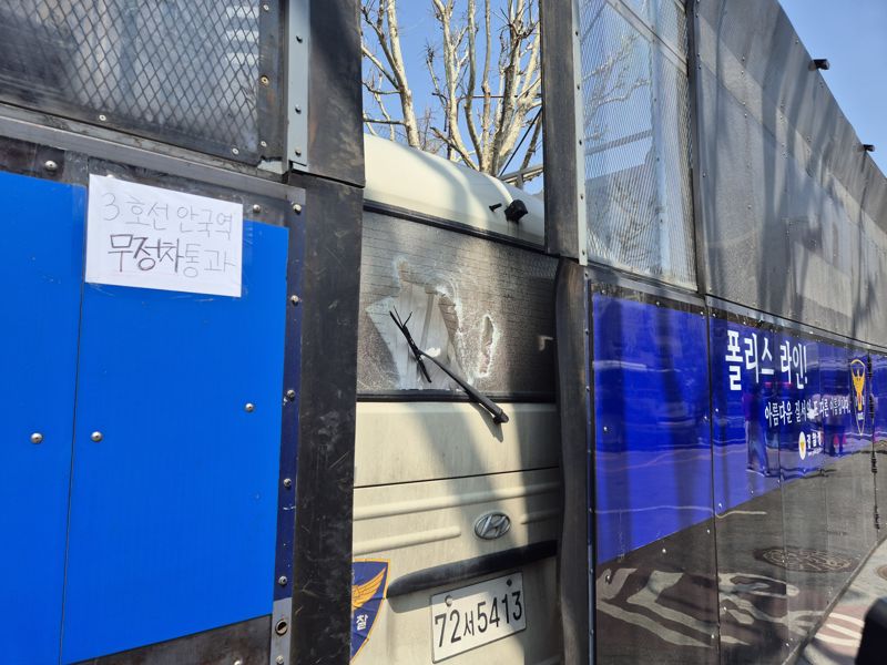 4일 윤석열 대통령 파면 선고 직후 군복을 입고 방독면을 쓴 한 남성이 방망이를 들고 경찰버스를 내리쳤다. 사진=김동규 기자