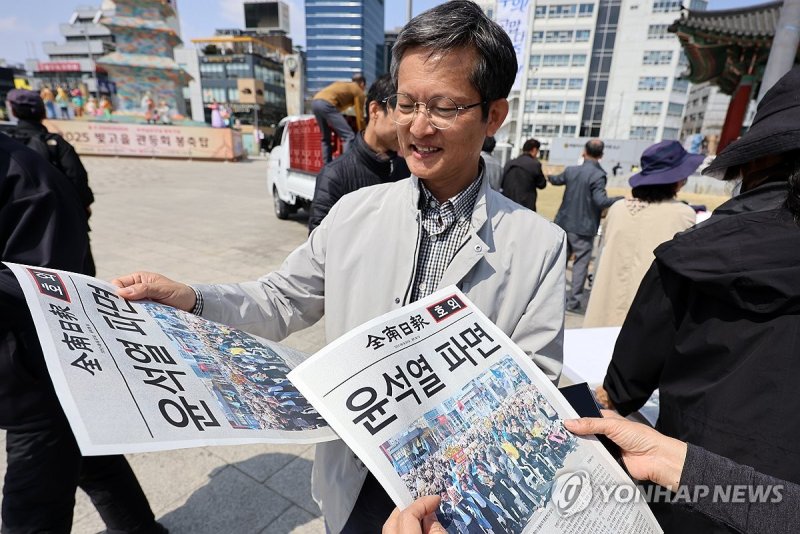 윤석열 파면 호외 보는 시민들 (출처=연합뉴스)