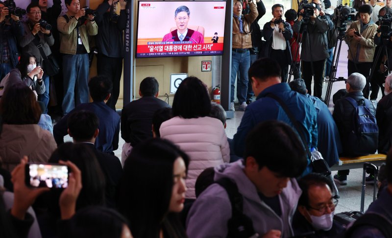 [서울=뉴시스] 박주성 기자 = 4일 오전 서울 용산구 서울역 역사에서 시민들이 윤석열 대통령 탄핵심판 선고를 시쳥하고 있다. 2025.04.04. park7691@newsis.com