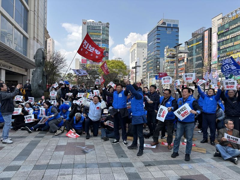 4일 오전 헌법재판소에서 윤석열 대통령 파면 선고가 내려지자 롯데백화점 울산점 앞 탄핵 찬성 집회 참가자들이 앉았던 자리에서 일어나 크게 환호하고 있다. 사진=최수상 기자