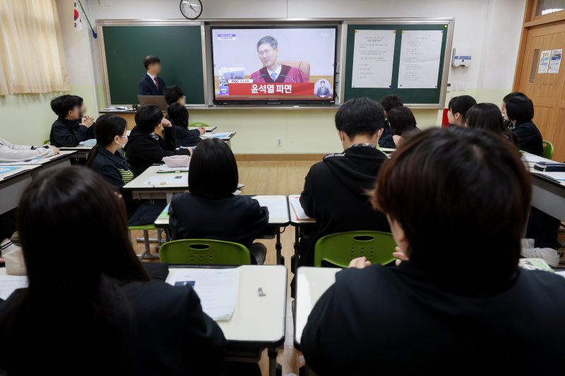 [서울=뉴시스] 김진아 기자 = 4일 오전 서울의 한 중학교에서 학생들이 대한민국 헌법으로 살펴보는 12·3 비상계엄사태 수업 중 '윤석열 대통령 탄핵 심판 선고' 생방송을 시청하고 있다. 2025.04.04. bluesoda@newsis.com