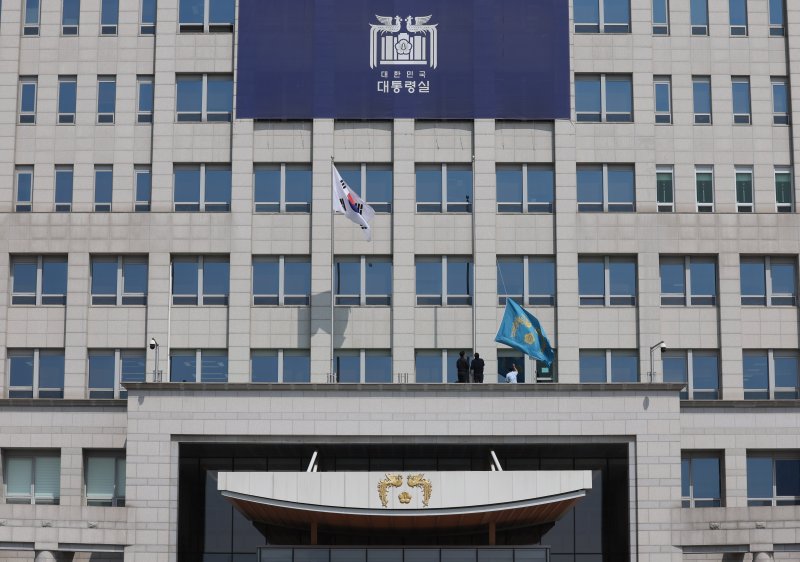 [서울=뉴시스] 조수정 기자 = 헌법재판소가 윤석열 대통령의 탄핵사건에 대해 인용을 선고한 4일 서울 용산 대통령실 청사에서 관계자들이 봉황기를 하기하고 있다. 2025.04.04. chocrystal@newsis.com