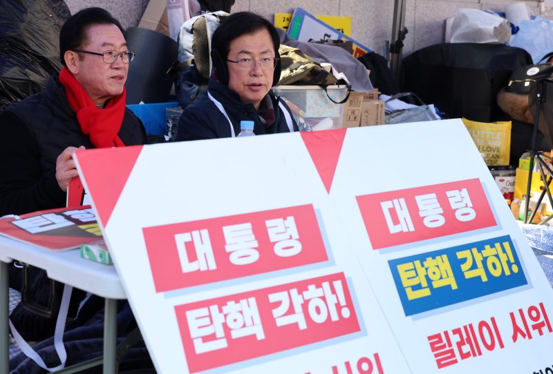 [서울=뉴시스] 이영환 기자 = 국민의힘 이종배(왼쪽), 이만희 의원이 19일 오후 서울 종로구 헌법재판소 앞에서 탄핵 각하를 촉구하는 릴레이 시위를 하고 있다. 2025.03.19. 20hwan@newsis.com
