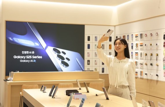 삼성스토어 신세계 시흥프리미엄아울렛 스마트폰 코너에서 모델이 갤럭시 S25를 체험하고 있다.