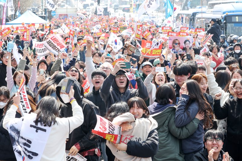 4일 오전 서울 용산구 대통령 관저 앞 도로에서 진보단체 회원들을 비롯한 시민들이 헌재의 윤석열 대통령에 대한 탄핵 선고 소식에 기뻐하고 있다. 2025.4.4/뉴스1 ⓒ News1 민경석 기자