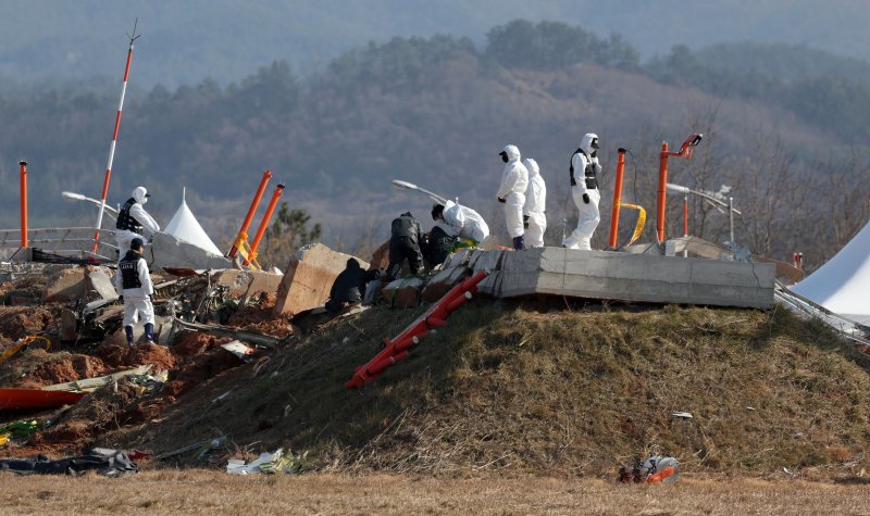 지난 1월 2일 전남 무안국제공항 제주항공 여객기 참사 현장에서 항공·철도사고 조사위원회(ARAIB) 관계자들이 로컬라이저(방위각 표시 시설)가 설치된 콘크리트 둔덕을 조사하고 있다. 뉴시스