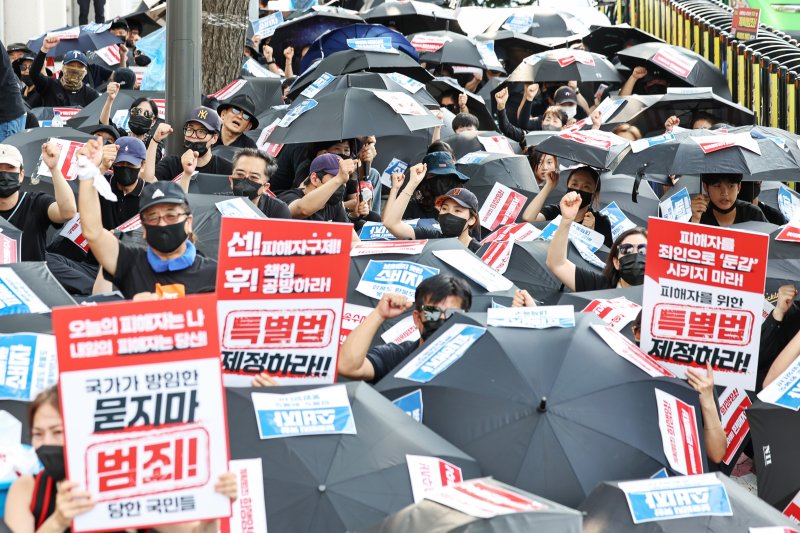 '티메프 사태' 피해자들이 18일 오후 서울 종로구 사직로 일대에서 열린 검은우산 집회에서 구호를 외치고 있다. 이날 참가자들은 정부에 실효성 있는 구제방안 마련과 특별법 제정을 촉구했다. 2024.8.18/뉴스1 ⓒ News1 민경석 기자