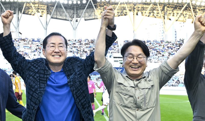 [광주=뉴시스] 강기정 광주시장과 홍준표 대구시장이 프로축구 광주FC와 대구FC의 경기 전 화합을 위해 손을 맞잡고 있다. (사진=광주시 제공) photo@newsis.com *재판매 및 DB 금지