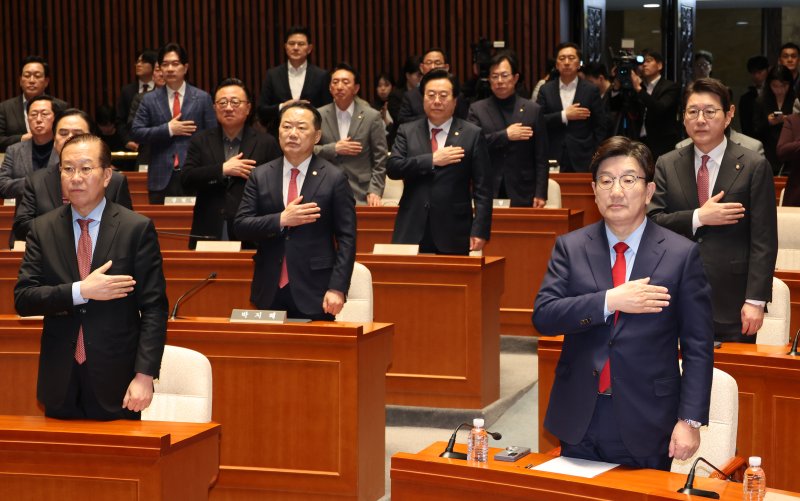 [서울=뉴시스] 조성우 기자 = 권영세(앞줄 왼쪽부터) 국민의힘 비상대책위원장과 권성동 원내대표 등 당 소속 의원들이 윤석열 전 대통령이 파면된 4일 서울 여의도 국회에서 열린 의원총회에서 국기에 대한 경례를 하고 있다. 2025.04.04. xconfind@newsis.com