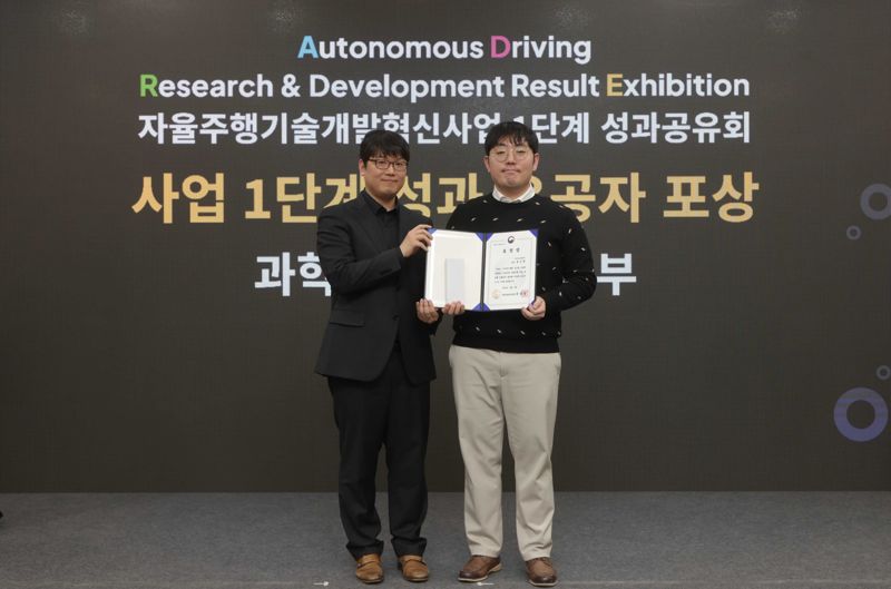 지난 4일 일산킨텍스에서 열린 ‘자율주행기술개발혁신사업’ 1단계 성과공유회에서 카카오모빌리티 홍승환 책임연구원(오른쪽)과 과학기술정보통신부 송창종 디바이스AX혁신팀장이 기념촬영을 하고 있다. 카카오모빌리티 제공