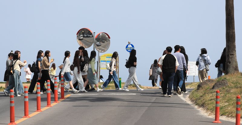 [제주=뉴시스] 우장호 기자 = 봄기운이 완연한 9일 오전 제주시 조천읍 함덕해수욕장 인근 도로에 수학여행을 온 학생들이 무리지어 길을 건너고 있다. 2025.04.09. woo1223@newsis.com