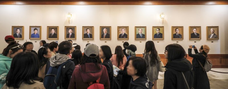 [서울=뉴시스] 정병혁 기자 = 9일 서울 종로구 청와대를 찾은 관람객들이 본관 세종실에 설치된 역대 대통령 초상화를 살펴보고 있다.윤석열 전 대통령에 대한 헌법재판소의 탄핵 선고 후 청와대를 찾는 발길이 늘어나고 있다. 광화문 등 인근에서 이어지던 탄핵 시위가 멈춘 데다, 조기 대선 후 대통령 집무실의 청와대 복귀 가능성도 나오는데 따른 변화로 읽힌다. 2025.04.09. jhope@newsis.com