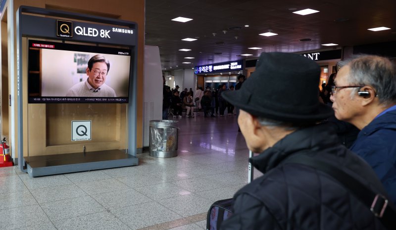 [서울=뉴시스] 홍효식 기자 = 10일 서울역 대합실에서 시민들이 이재명 더불어민주당 전 대표의 대통령 선거 출마 선언 영상을 시청하고 있다. 2025.04.10. yesphoto@newsis.com