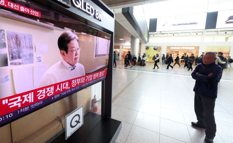 [서울=뉴시스] 홍효식 기자 = 10일 서울역 대합실에서 한 시민이 이재명 더불어민주당 전 대표의 대통령 선거 출마 선언 영상을 시청하고 있다. 2025.04.10. yesphoto@newsis.com