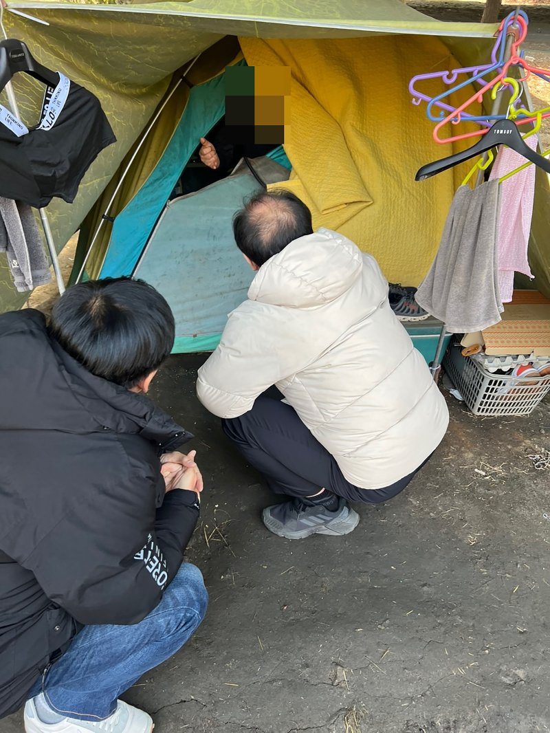 [성남=뉴시스] 성남시노숙인종합지원센터 종사자들이 모란역 인근에 텐트를 치고 생활 중인 노숙인을 지원하기 위해 대화를 시도 중이다 (사진=성남시 제공) 2025.04.10.photo@newsis.com