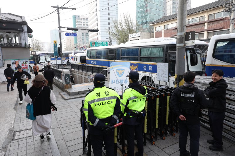 [서울=뉴시스] 김금보 기자 = 관광객이 8일 오전 서울 종로구 헌법재판소 맞은편 보행로에서 경찰의 경비 속에 통행하고 있다. 2025.04.08. kgb@newsis.com