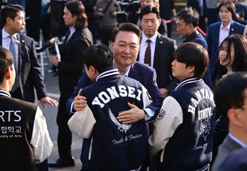 윤석열 전 대통령이 11일 오후 서울 용산구 한남동 관저 정문에서 퇴거하며 배웅 나온 학생들과 포옹하고 있다. (공동취재) 2025.4.11/뉴스1 ⓒ News1 김성진 기자