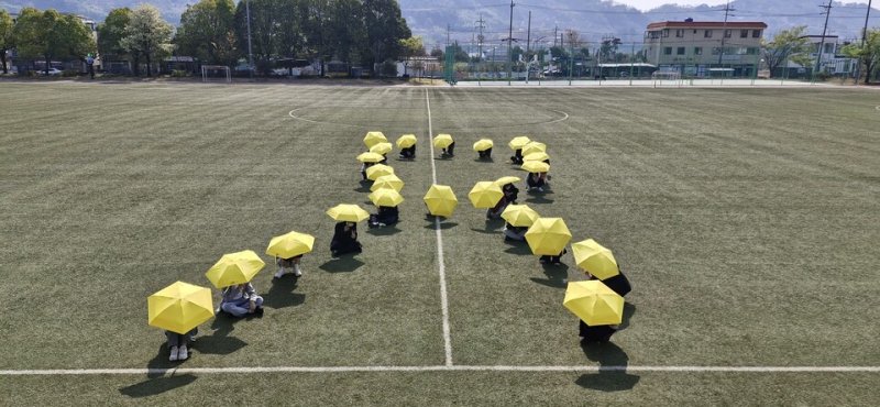 학생들이 학교 운동장에서 노란우산을 펼치고 세월호 참사를 추모하고 있다.(전남도교육청 제공, 재판매 및 DB 금지)