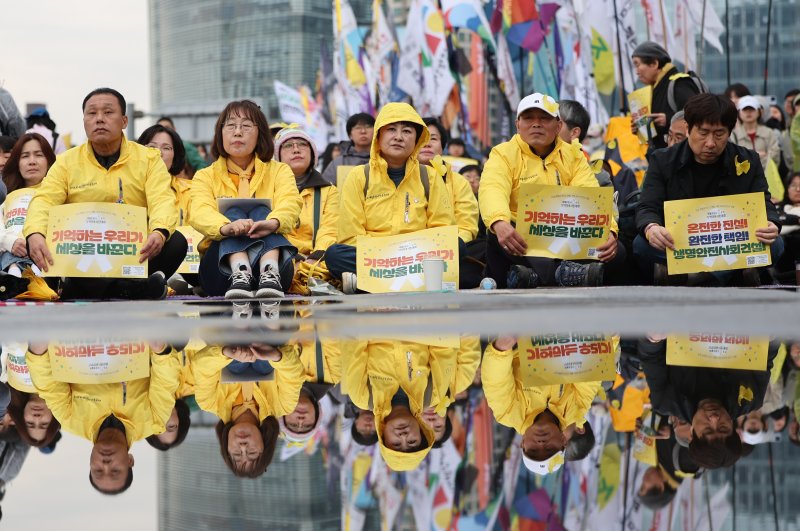 [서울=뉴시스] 황준선 기자 = 12일 오후 서울 종로구 경복궁 서십자각터에서 열린 세월호 참사 11주기 기억약속시민대회에서 세월호 참사 유가족들이 손피켓을 들고 있다. 2025.04.12. hwang@newsis.com