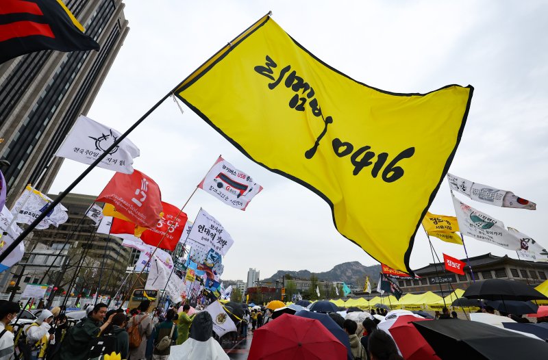 [서울=뉴시스] 황준선 기자 = 12일 오후 서울 종로구 경복궁 서십자각터에서 열린 세월호 참사 11주기 기억약속시민대회에서 참석자들이 깃발을 흔들고 있다. 2025.04.12. hwang@newsis.com