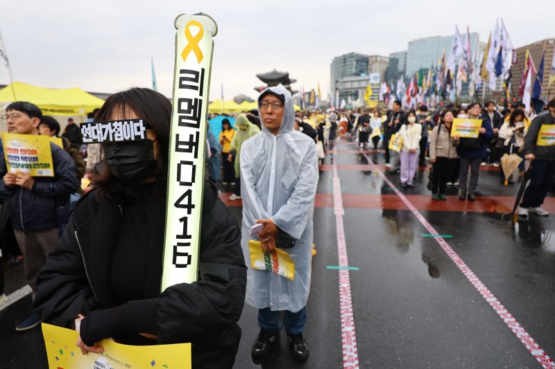 [서울=뉴시스] 황준선 기자 = 12일 오후 서울 종로구 경복궁 서십자각터에서 열린 세월호 참사 11주기 기억약속시민대회에서 참석자들이 손피켓을 들고 있다. 2025.04.12. hwang@newsis.com