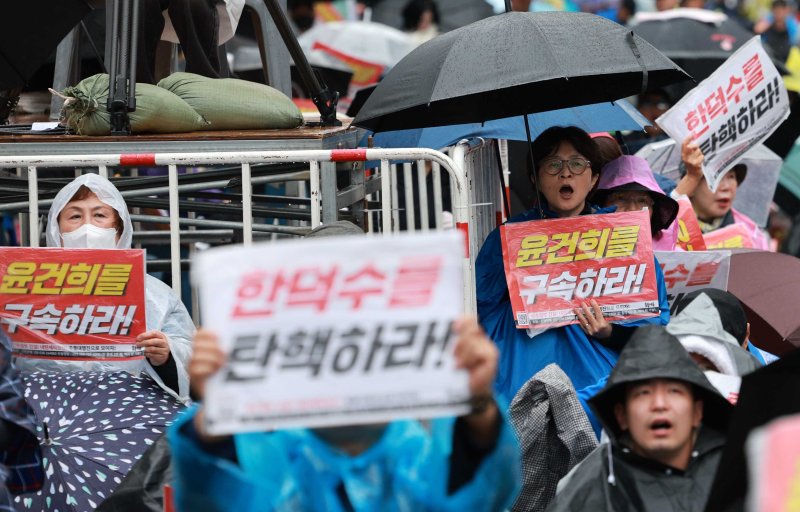 [서울=뉴시스] 고범준 기자 = 12일 서울 중구 서울시청역 인근에서 촛불행동 주최로 열린 135차 촛불대행진에서 참석자들이 손 피켓을 들고 있다. 2025.04.12. bjko@newsis.com