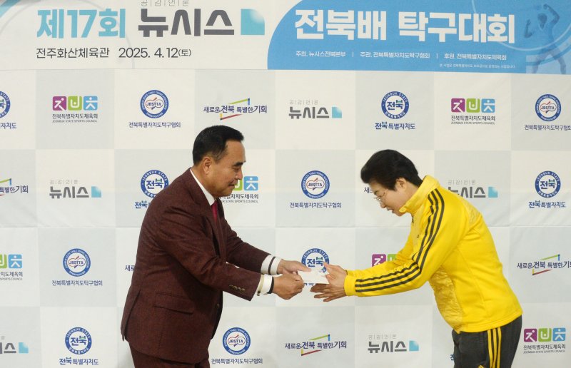 [전주=뉴시스] 김얼 기자 = 윤석일(왼쪽) 뉴시스 전북본부 본부장이 12일 전북 전주시 전주화산체육관에서 제17회 뉴시스 전북배 탁구대회를 열고 기념품을 전달하고 있다. 2025.04.12. pmkeul@newsis.com