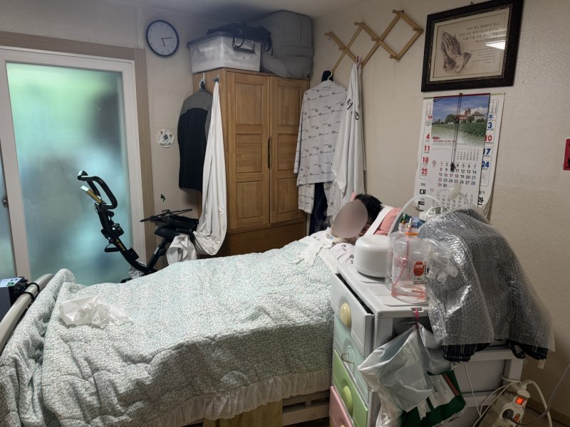 [서울=뉴시스] 한 돌봄청년 A군의 어머니가 침대에 누워 있다. A군의 어머니는 그가 3살 때 뇌출혈로 쓰러져 뇌병변 1급 장애 판정을 받았다. (사진=초록우산 제공) 2024.09.13. photo@newsis.com