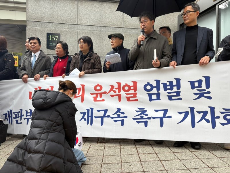 [서울=뉴시스]윤 전 대통령 탄핵을 주도해온 시민단체 '내란청산·사회대개혁 비상행동'이 14일 오전 9시 서울중앙지법 동문 앞에서 '내란수괴 윤석열 엄벌 및 재판부의 직권 재구속 촉구 기자회견'을 진행하던 중 윤석열 전 대통령 지지자로 추정되는 한 여성이 무릎을 꿇고 기도를 하고 있다.