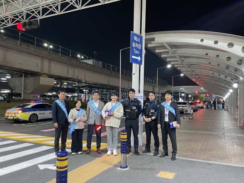 김해공항, 부산시 택시운수과, 공항 경찰대, 공항 파출소 관계자들이 불법 택시영업 계도 캠페인을 진행하며 기념사진을 찍고 있다.(김해공항 제공. 재판매 및 DB 금지)