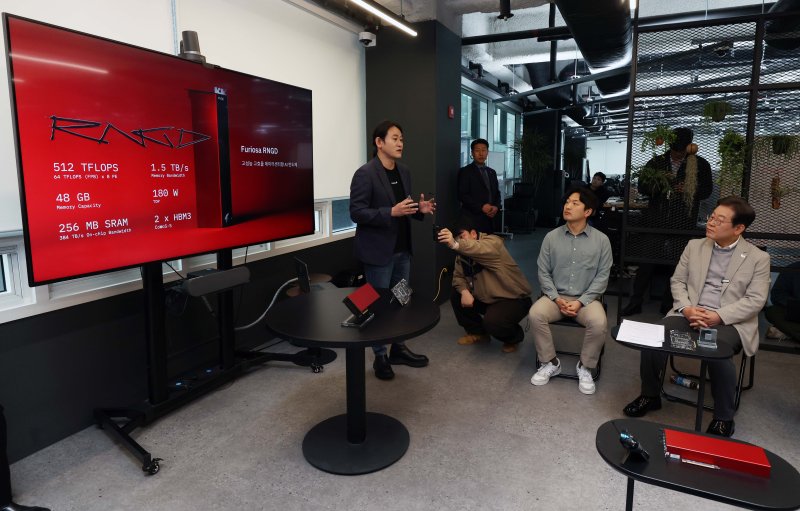 이재명 더불어민주당 대선 예비후보가 14일 서울 강남구 인공지능(AI) 반도체 스타트업 퓨리오사에서 백준호 대표에게 퓨리오사AI NPU 기술소개 및 시연을 듣고 있다. 2025.4.14/뉴스1 ⓒ News1 국회사진취재단