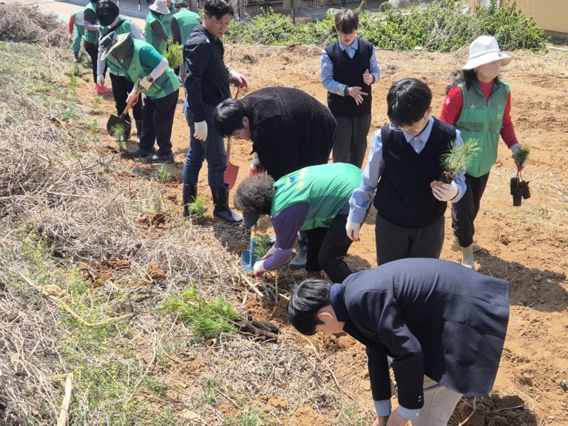 충북 진천군 새마을회(회장 김일권)는 14일 2050 탄소중립 실천을 위해 진천중학교에 잣나무 2000그루를 심었다.(진천군 제공)/뉴스1