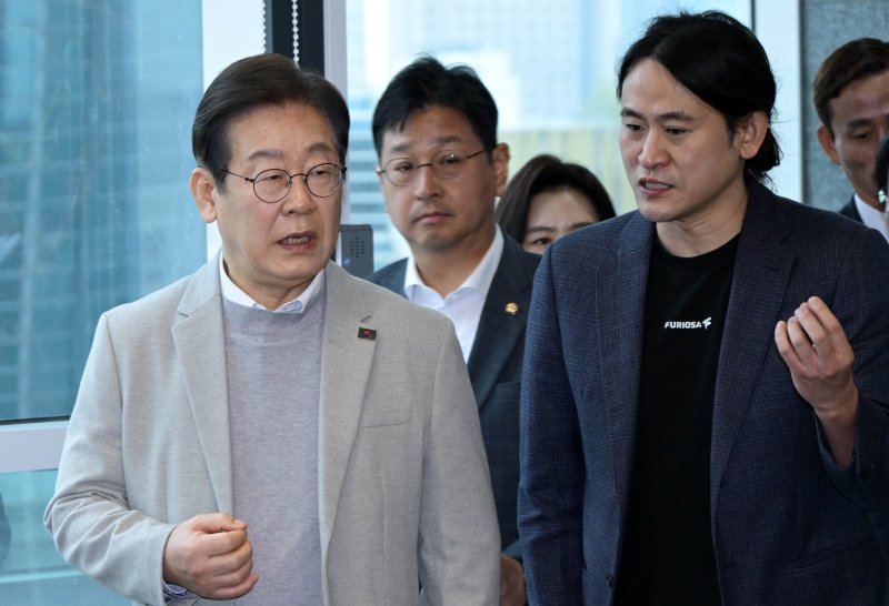 [서울=뉴시스] 국회사진기자단 = 제21대 대통령 선거 출마를 선언한 이재명(왼쪽) 더불어민주당 전 대표가 지난 14일 서울 강남구 퓨리오사AI에서 백준호 퓨리오사AI 대표와 대화하며 이동하고 있다. 2025.04.14. photo@newsis.com